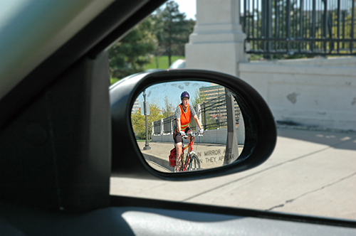 Bike rider seen in car side mirror